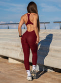 Back profile shot of our model in outdoors wearing the Athletic Bodysuit in Black Cherry color