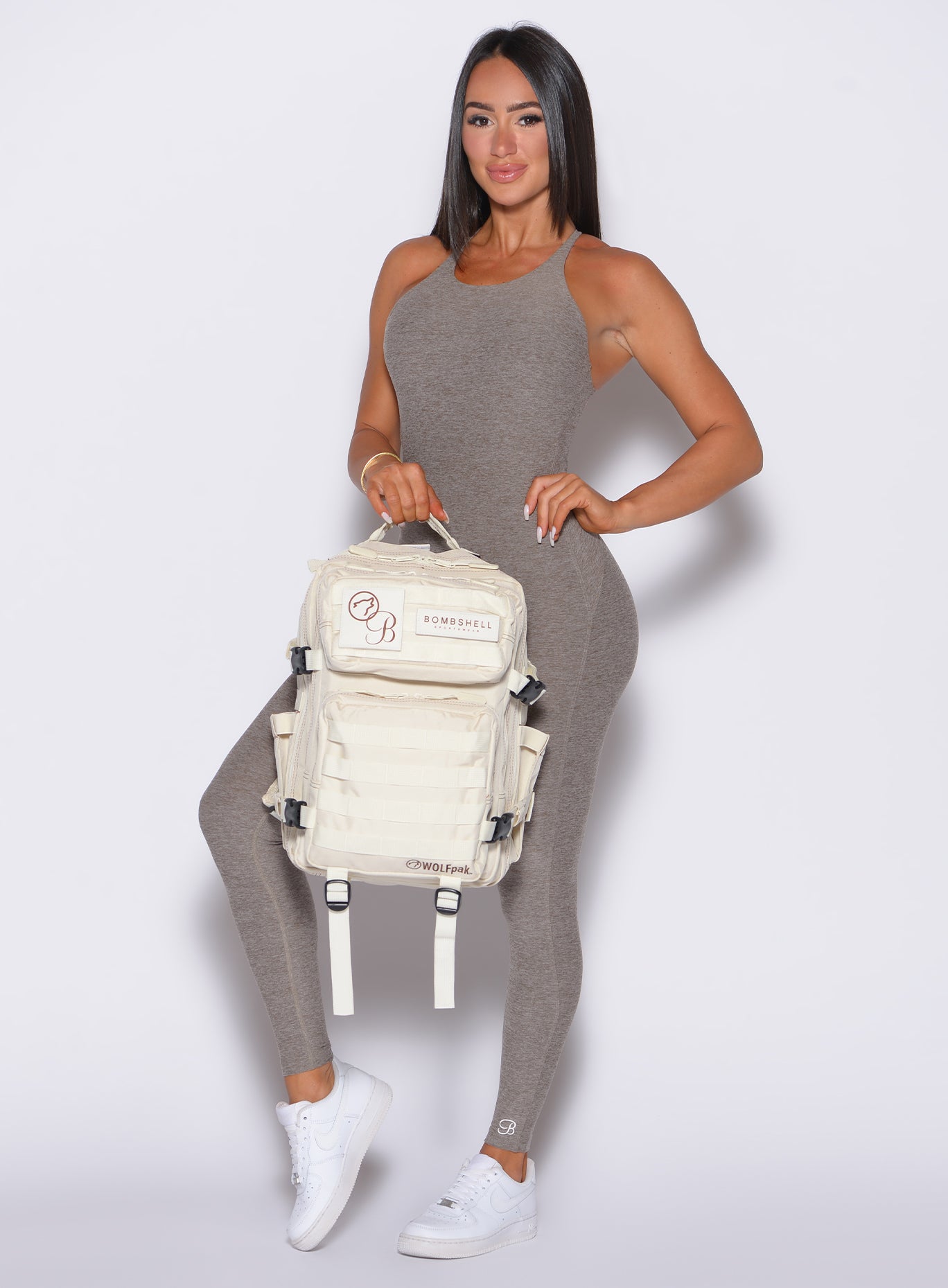 Front profile view of our model equipped with the Bombshell X WOLFpak collaboration backpack wearing the Bombshell Bunny Bodysuit 2.0 in Smoked Taupe color