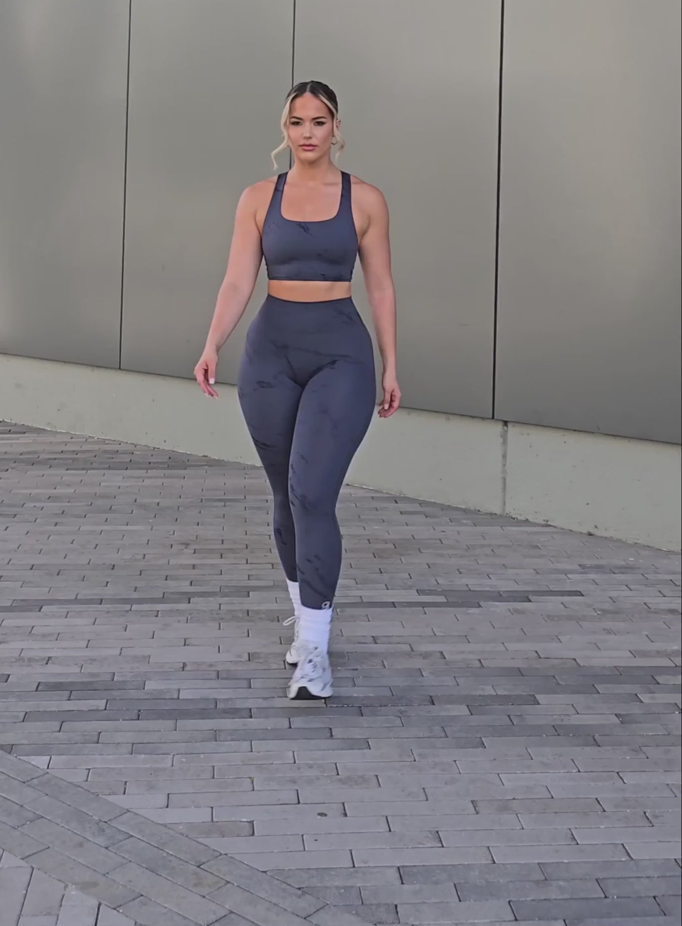 A short video of a model  wearing our fit marble leggings in thunder gray color along with a matching bra