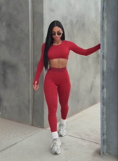 A short video showcasing our model walking in outdoors wearing the Bombshell Active Leggings in Red ochre color paired with the matching pullover