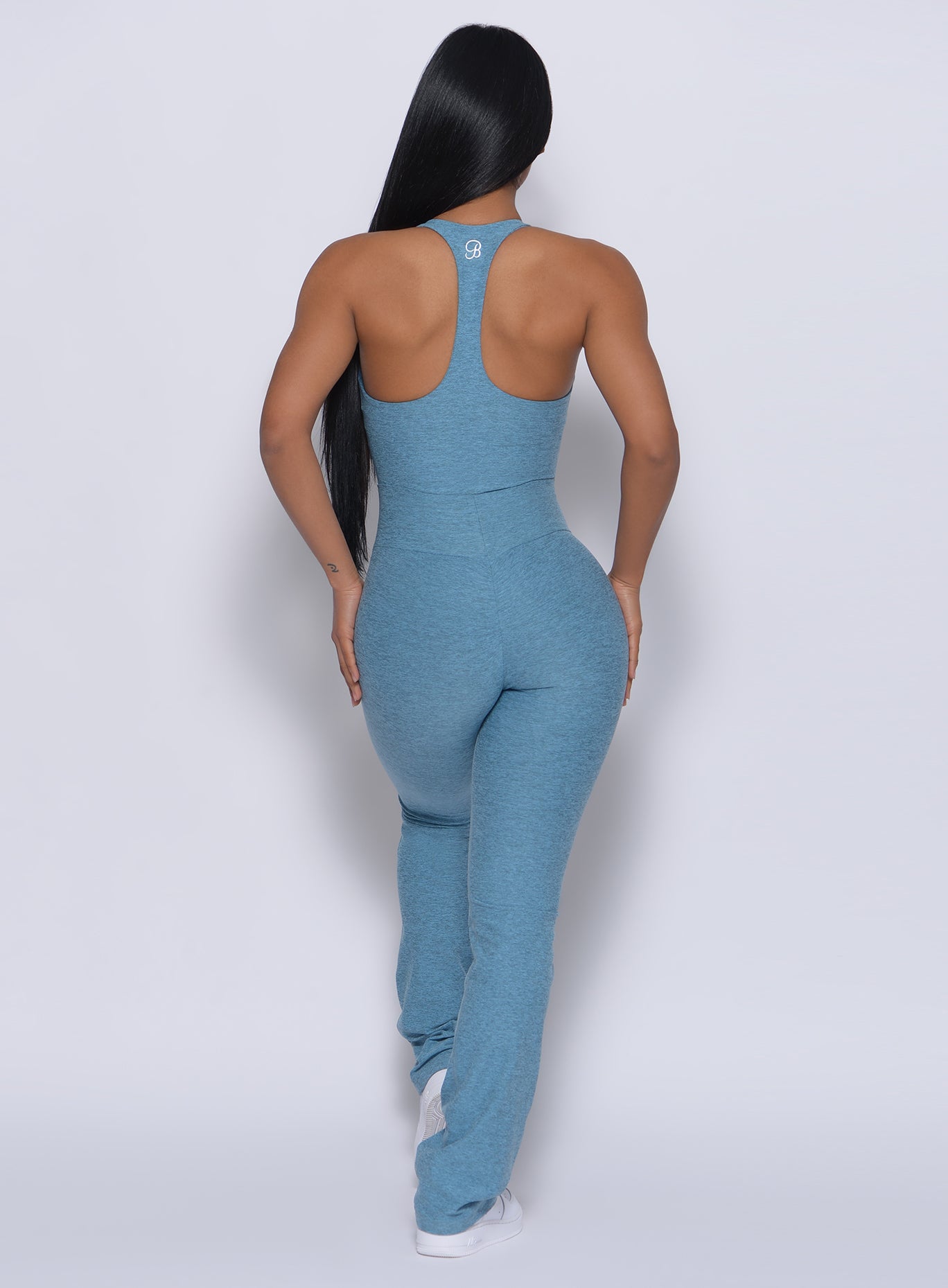 Back profile view of a model in our straight up leggings in baby blue color and a matching bodysuit