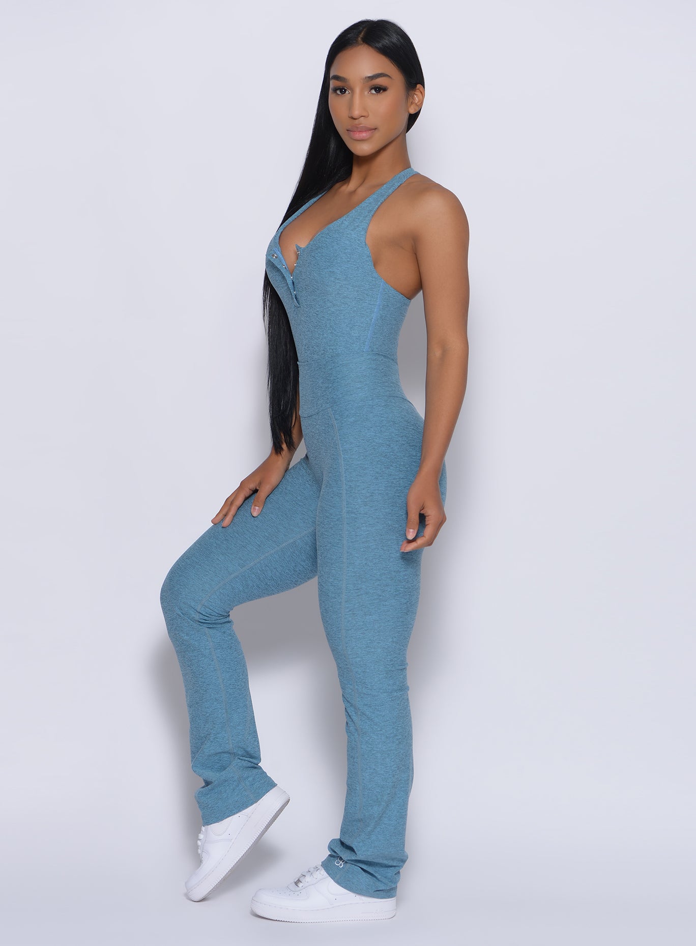 Left side profile view of a model in our straight up leggings in baby blue color and a matching bodysuit