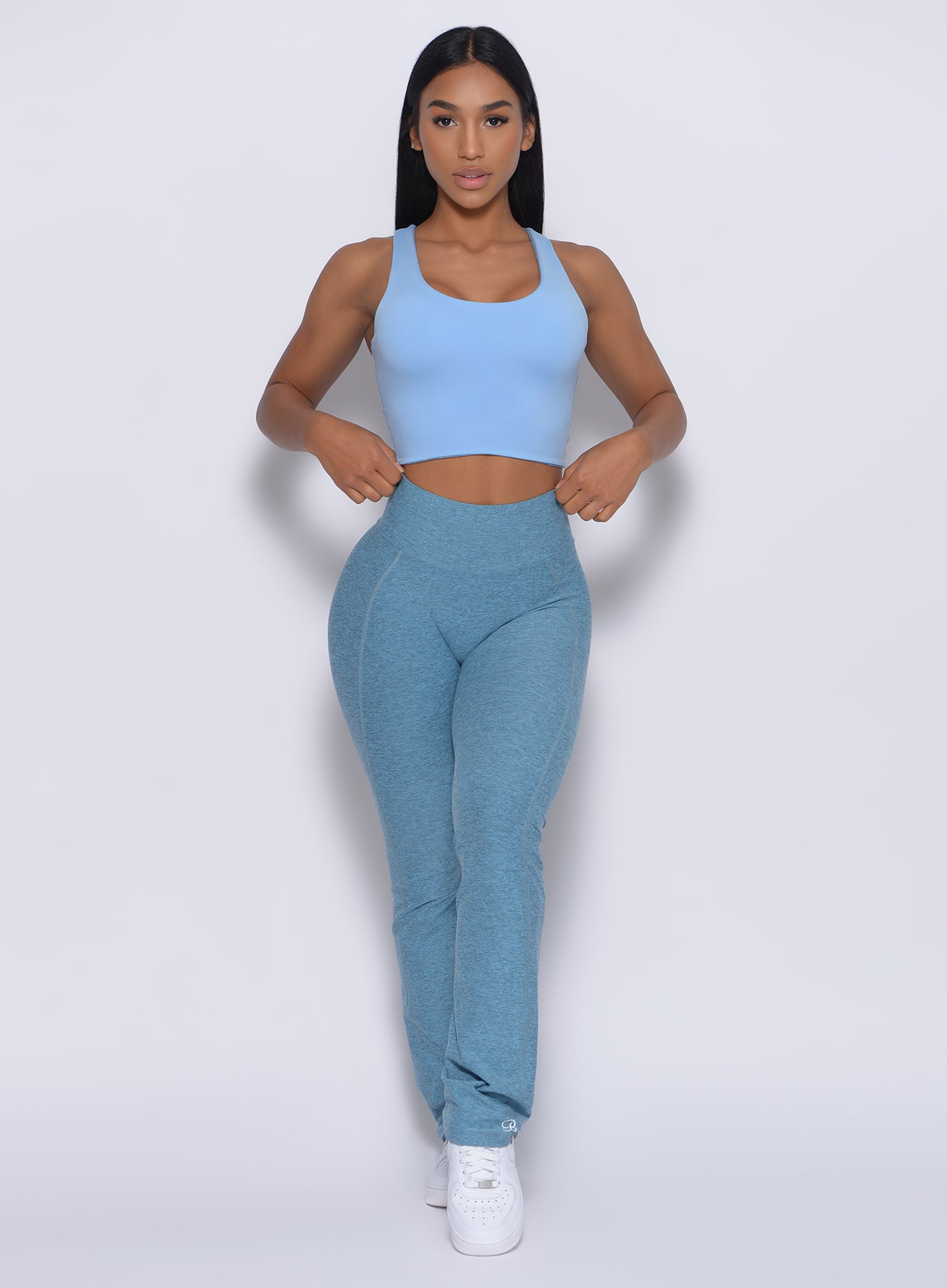 Front profile view of a model wearing our straight up leggings in baby blue color and a matching top