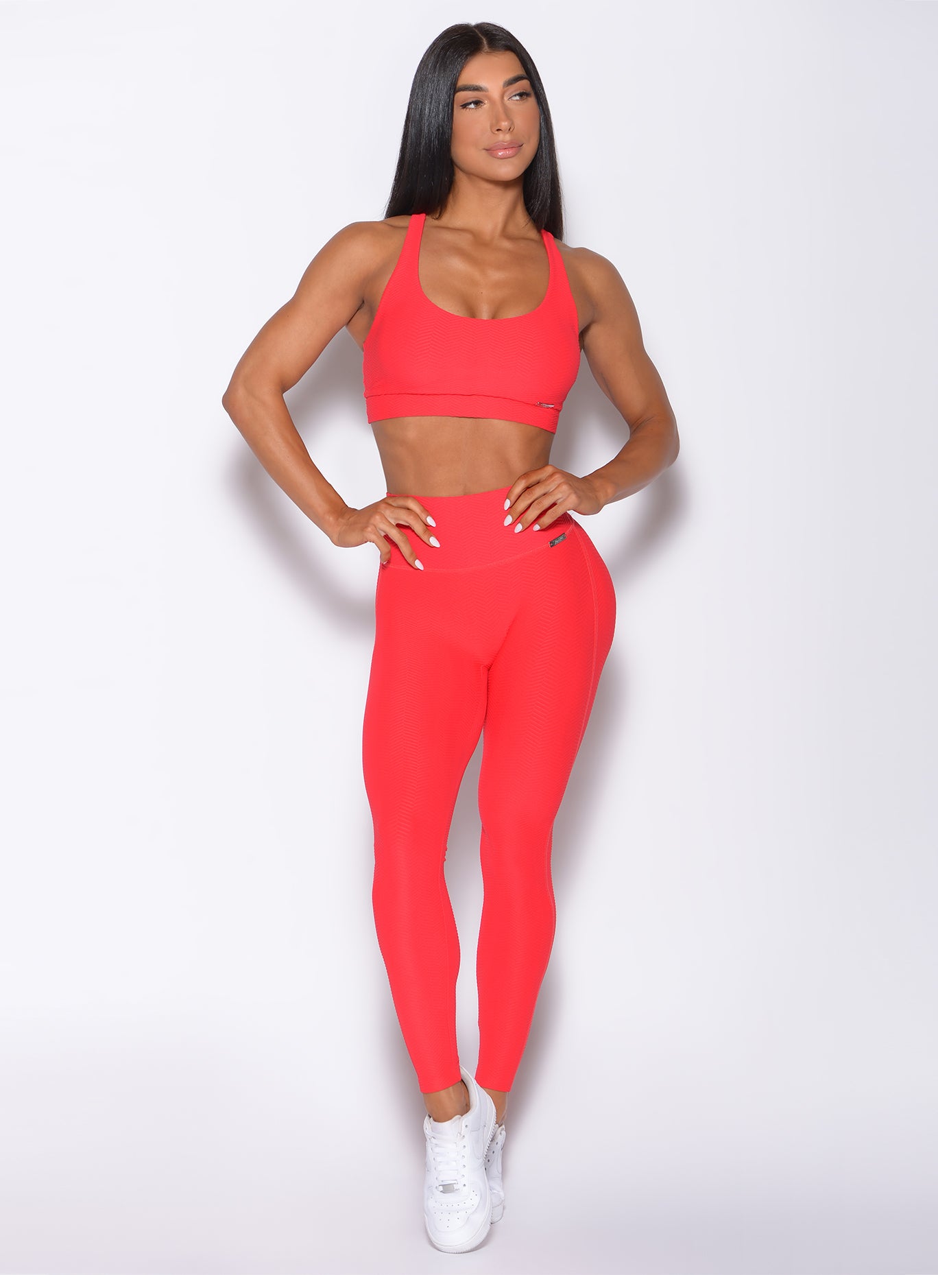 Front profile view of a model in our Chevron Leggings in flame red color and matching bra