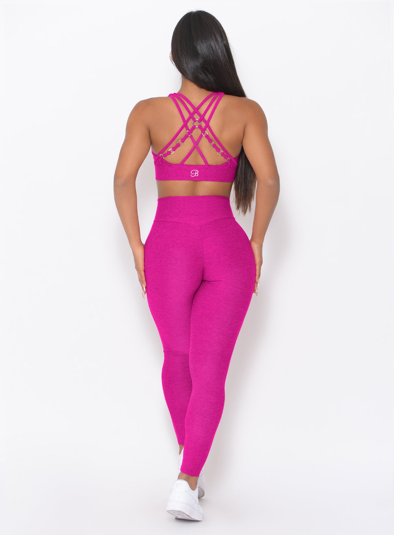 back profile of model wearing the Contour Leggings in Ultra Pink color and a matching bra