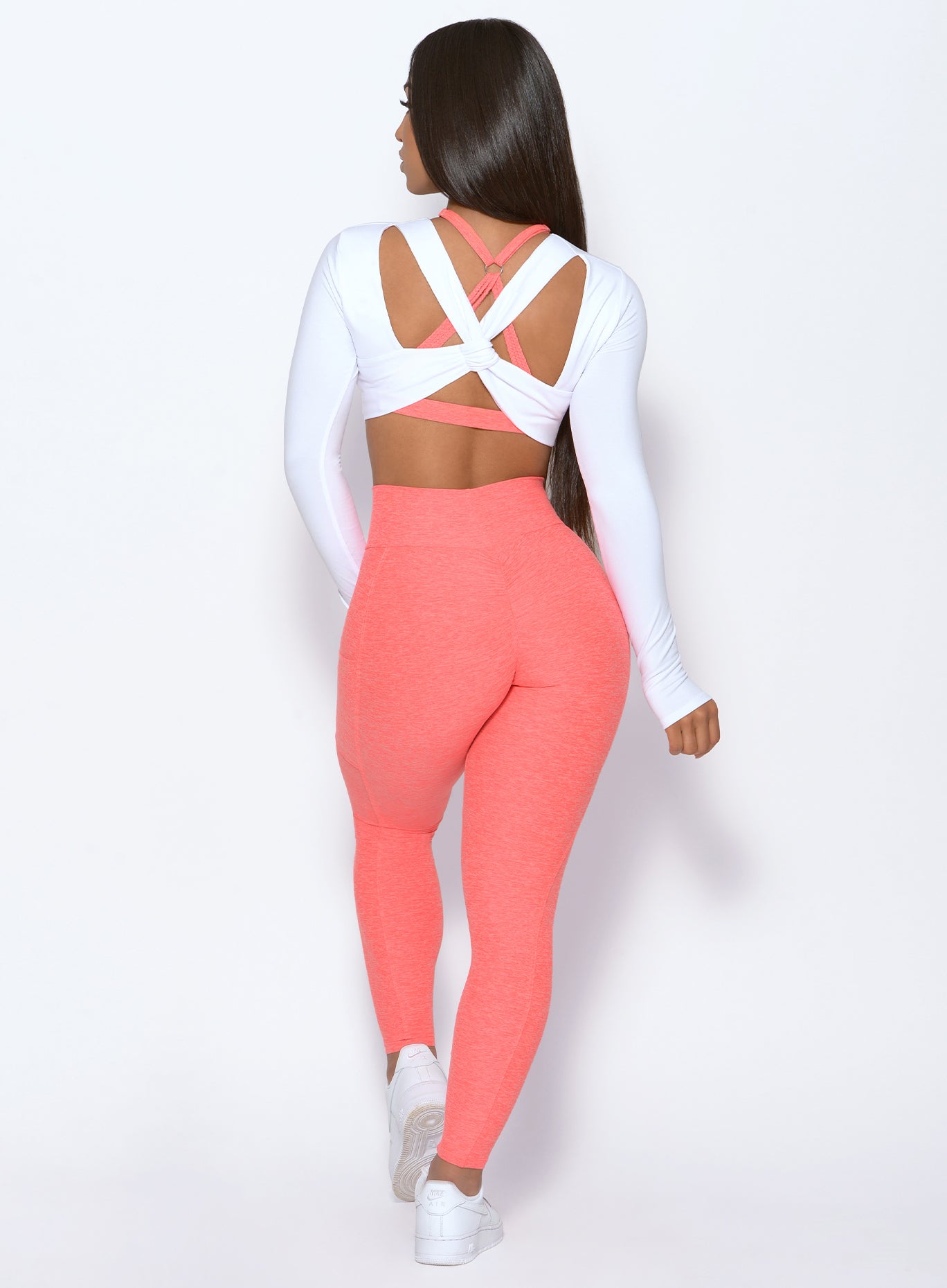 back profile of a model wearing our Curve leggings in Coral and our Pullover in White