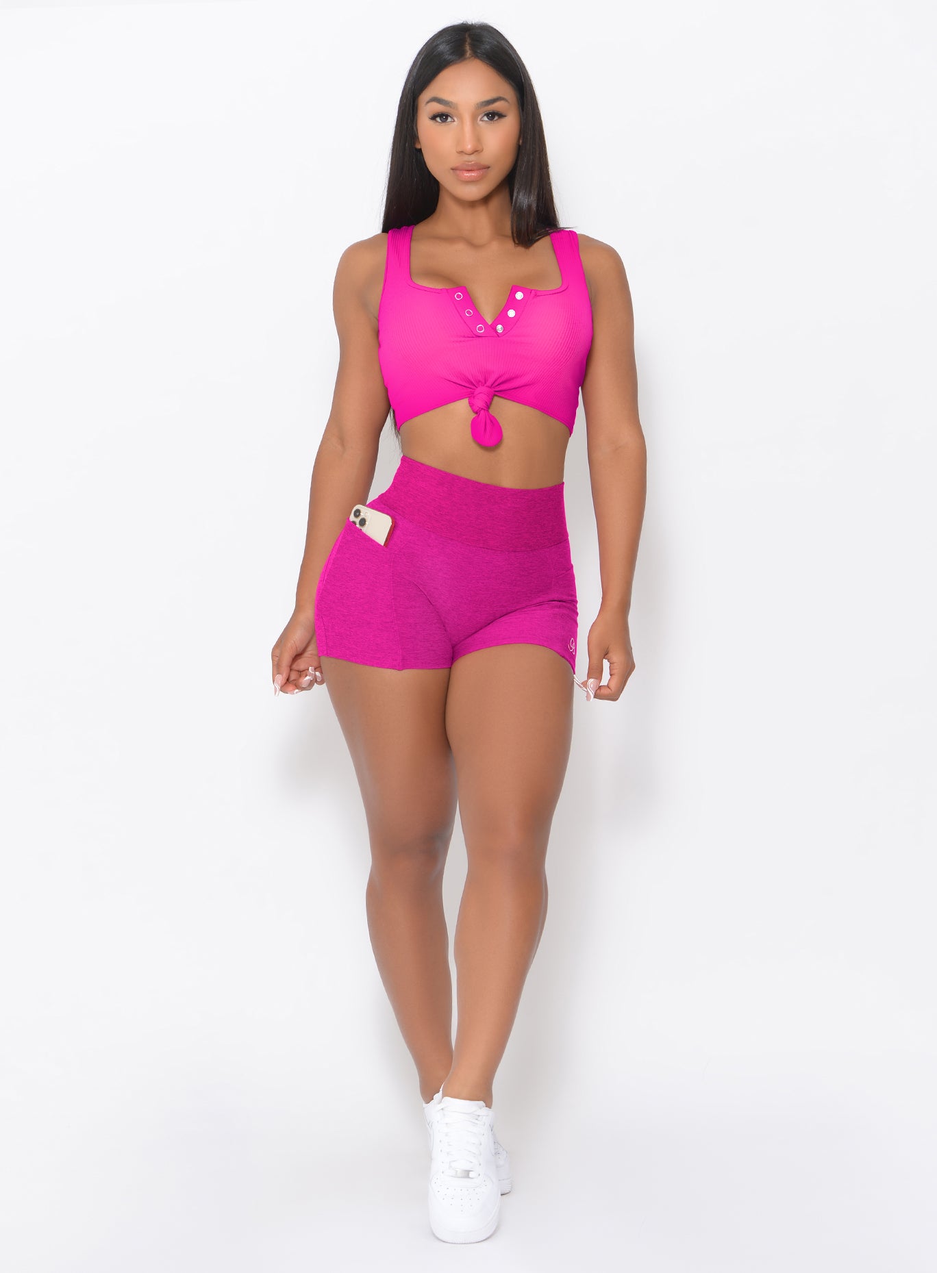 front profile view of a model wearing our Curves Shorts in Ultra Pink color and a matching Sports Bra
