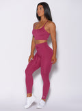 Left side profile view of a model angled left wearing our empower leggings in berry good color and a matching bra