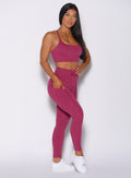 Right side profile view of a model angled right wearing our empower leggings in berry good color and a matching bra