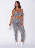 Front profile view of a model in our fit cheetah leggings in lightning gray color and a matching bra