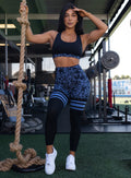 Front profile view of a model holding a rope wearing our scrunch thigh high in blue leopard print and a matching bra