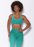 Front profile picture of a model in our toggle sports bra in Ombre Ibiza Green and a matching leggings