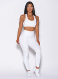 Front profile view of a model in our shine leggings in white python color and a matching bra