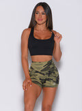 Model facing forward wearing our bright army camo straight up shorts and a black bra