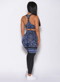 Back profile view of a model in our scrunch thigh high in blue leopard print and a matching bra