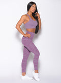 Left side profile picture of a model holding her hair wearing our rival sports bra in solid orchid color and a matching sexy back leggings in tiger print color