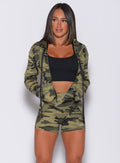 Front profile view of a model with her hands in pocket wearing our bright army camo signature jacket and a matching shorts