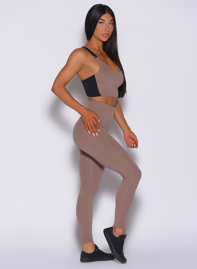 Right side profile view of a model wearing our snatched waist leggings in cocoa color and a matching bra