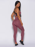 Right side profile view of a model in our snatched waist leggings in merlot color and a matching bra