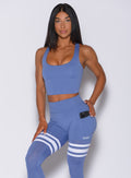 Front profile view of a model wearing our ultimate tank bra in denim blue color and a matching leggings